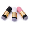 Three makeup brushes with black bristles and gold accents on a white background